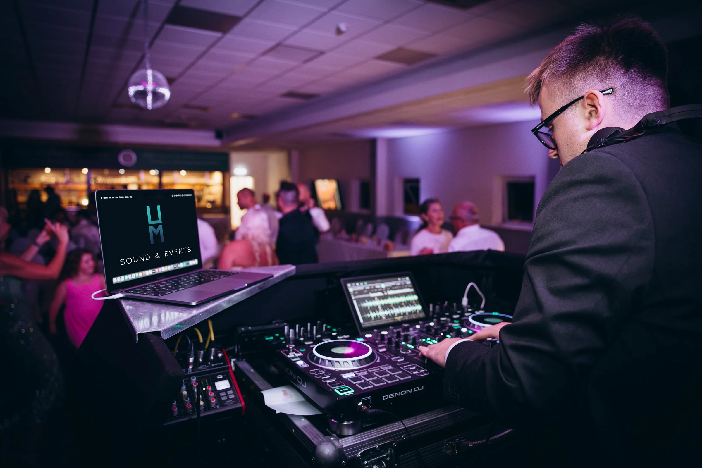 Harry using a Denon DJ controller and Laptop at a party.